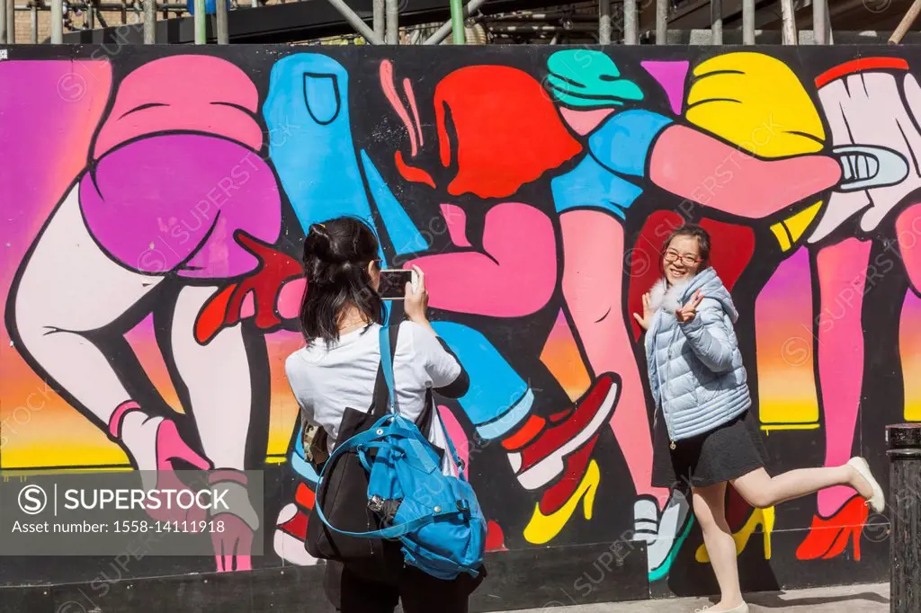 England, London, Shoreditch, Spitalfields Market, Asian Tourists Posing with Wall Art
