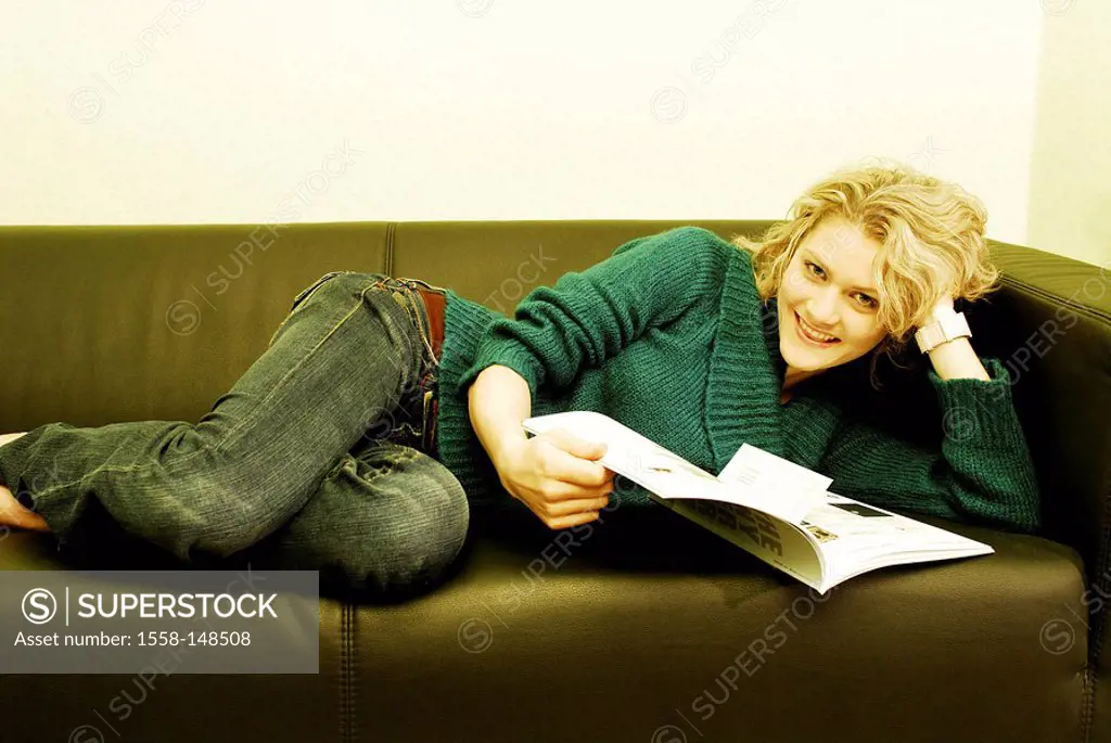 Lies woman, young, blond, magazine, sofa, cheerfully, smiling, watching, camera,