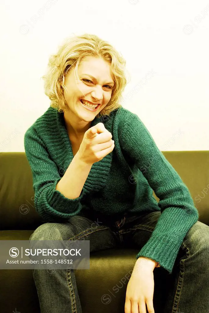 Sits, woman, young, blond, magazine, sofa, laughing, gesture, shows,