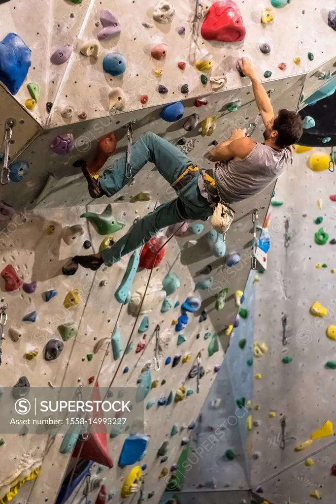 Germany, Baden-Württemberg, Stuttgart, climbing gym, female climber in an overhang on the climbing wall