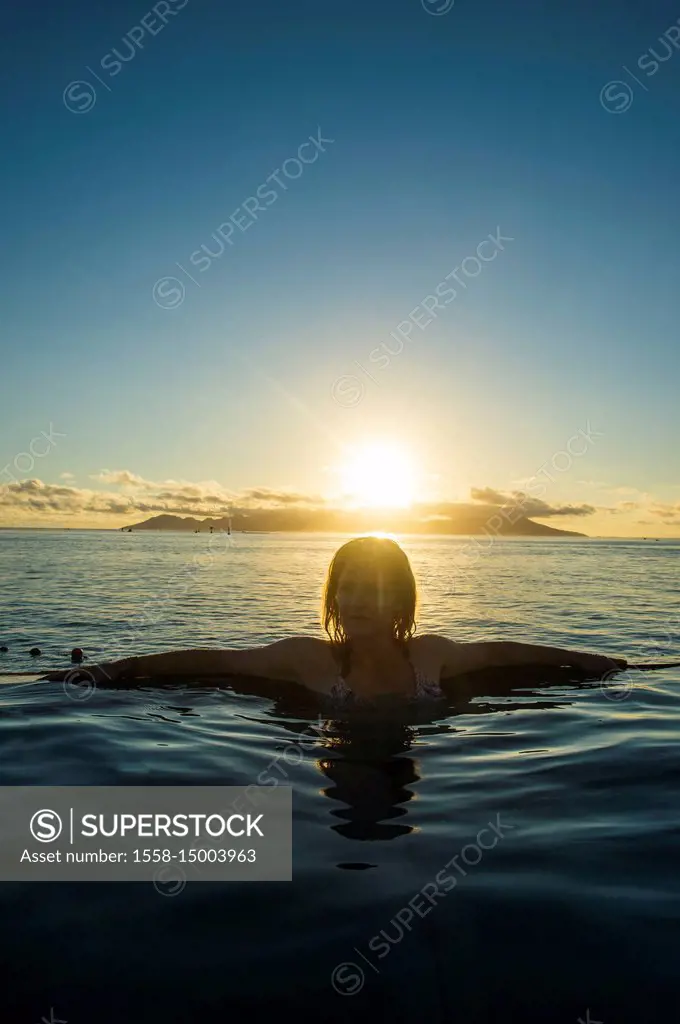 Woman enjoying the sunset in a swimming pool, Papeete, Tahiti, French Polynesia