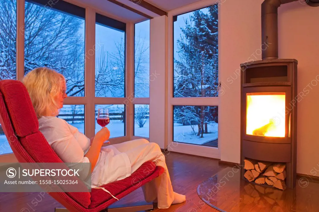 Woman in the living room at a chimney in the winter,