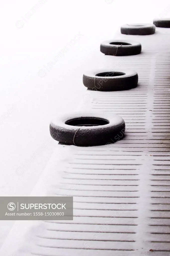 Snow covered car tires on the wooden pier