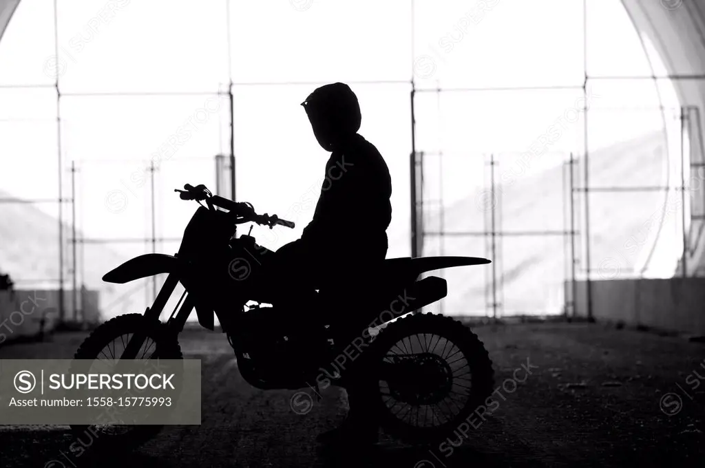 Motorcyclist stands in a tunnel,