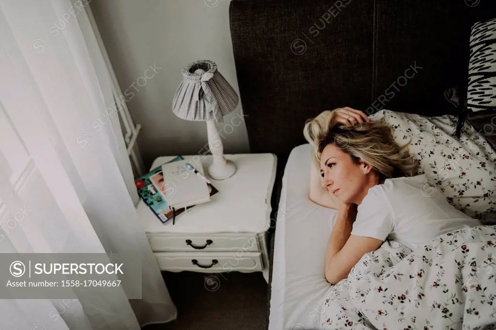 Woman lies in bed thoughtfully