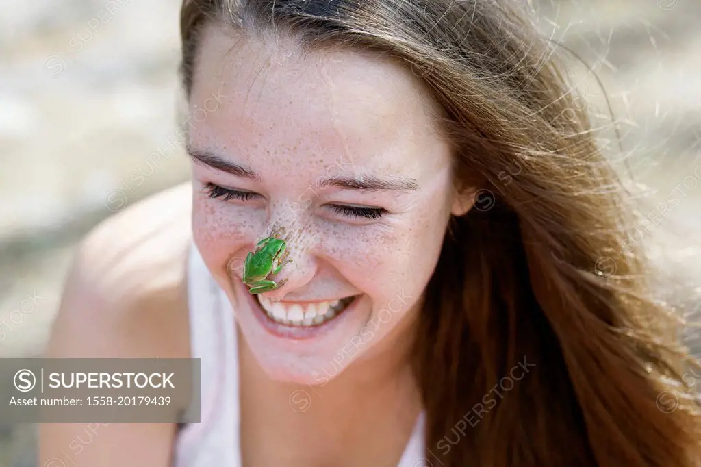 young woman with frog on nose
