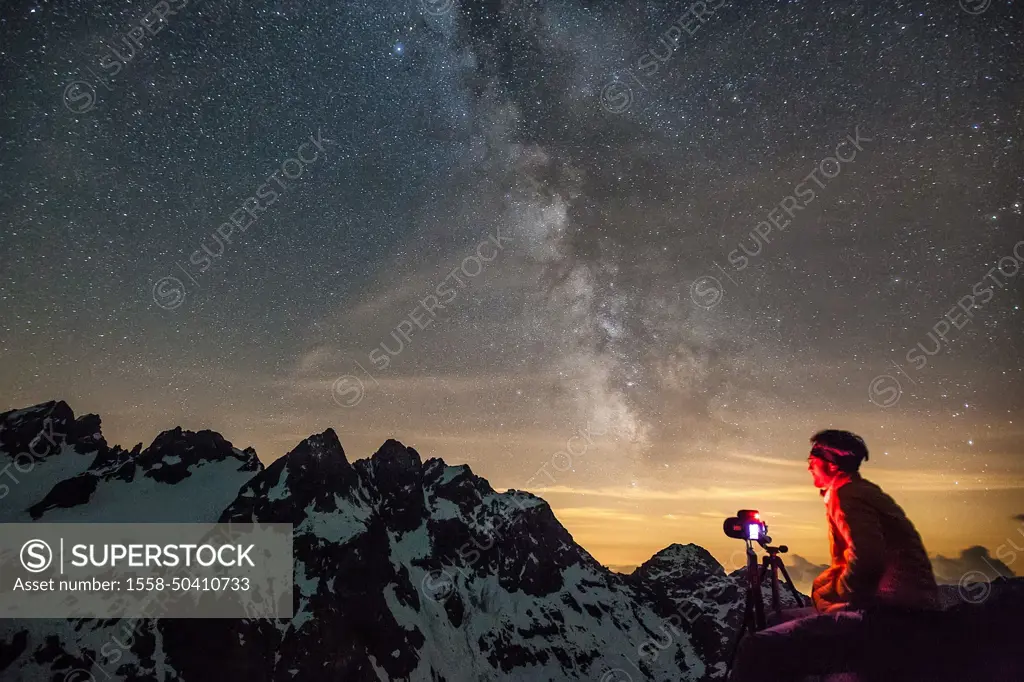 Photographer working to catch the Milky Way on Cime di Musella from Martinelli Refuge. Martenelli Refuge, Valmalenco, Valtellina, Lombardy, Italy.