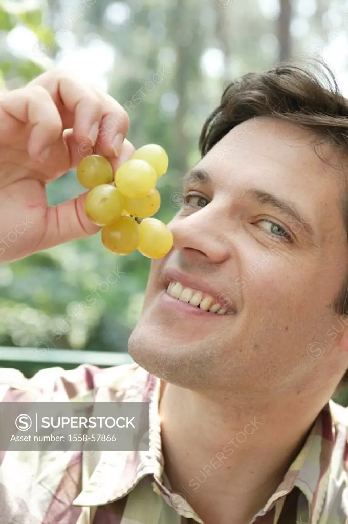 Man, smiles, grapes, eats