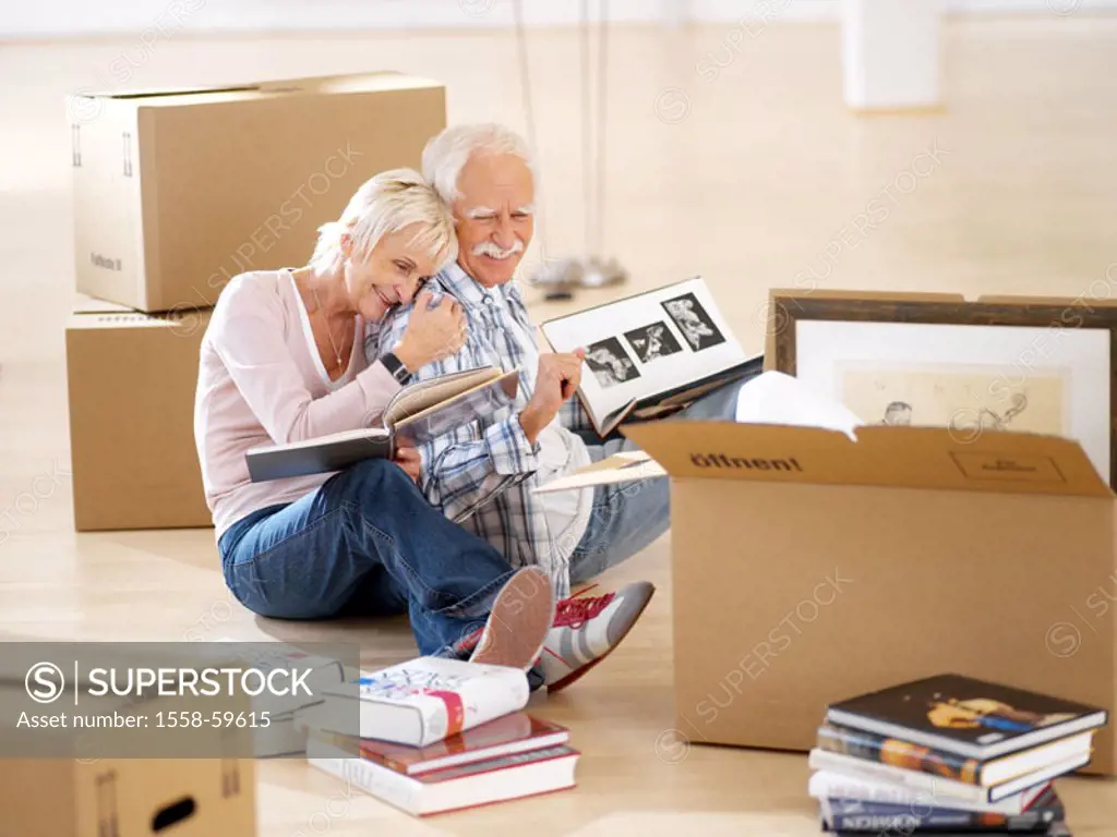 Sits move, senior pair, floor,  Carton, empties, books, looks at   60-70 years, couples, couple, pair, seniors, pensioners, move carton, Büchersammlun...