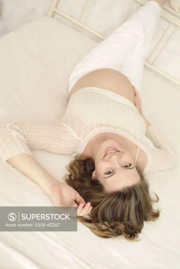 Bed, pregnant, smiling, showing one´s bellybutton,  Relaxation, legs put up  Series, woman, young, 20-30 years, 30-40 years, long-haired, brown-haired...