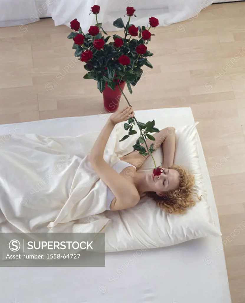 Woman, young, happily, bed, lie,  Vase, rose bouquet, rose, smells  23 years, 20-30 years, blond,  indoors, leisure time, at home, lie, covered, dream...