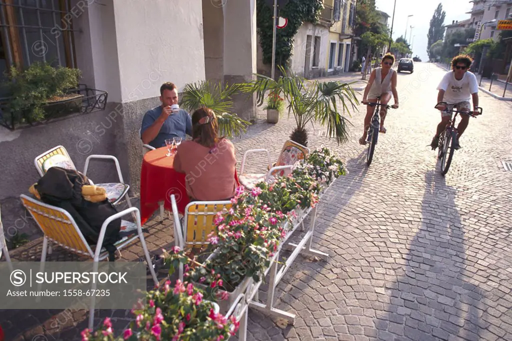 Italy, Trentino, Lake Garda, Torbole,  Street pub, people,  Vacation, leisure time, tourists, 30-40 years, couple, cyclists, street cafe, restaurant, ...