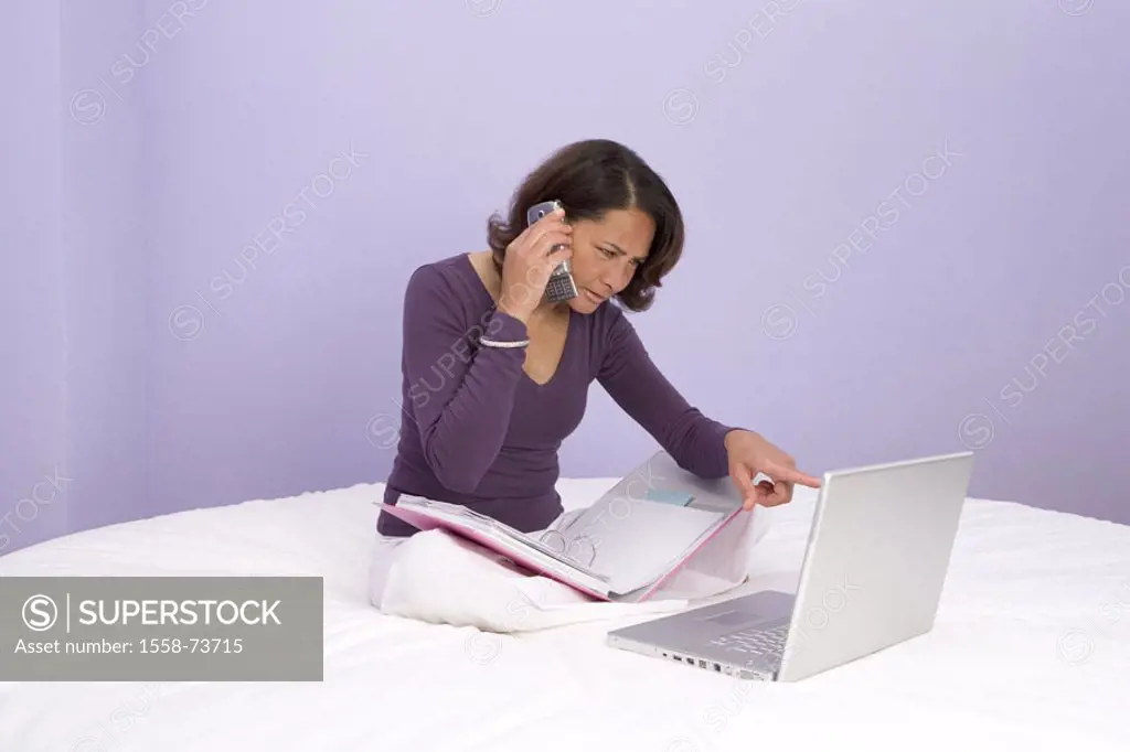 Woman, middle age, laptop, cell phone,  File folders, bed, gesture, sit  50 years, works at home, computers, telephone, portable phone, telephones, se...