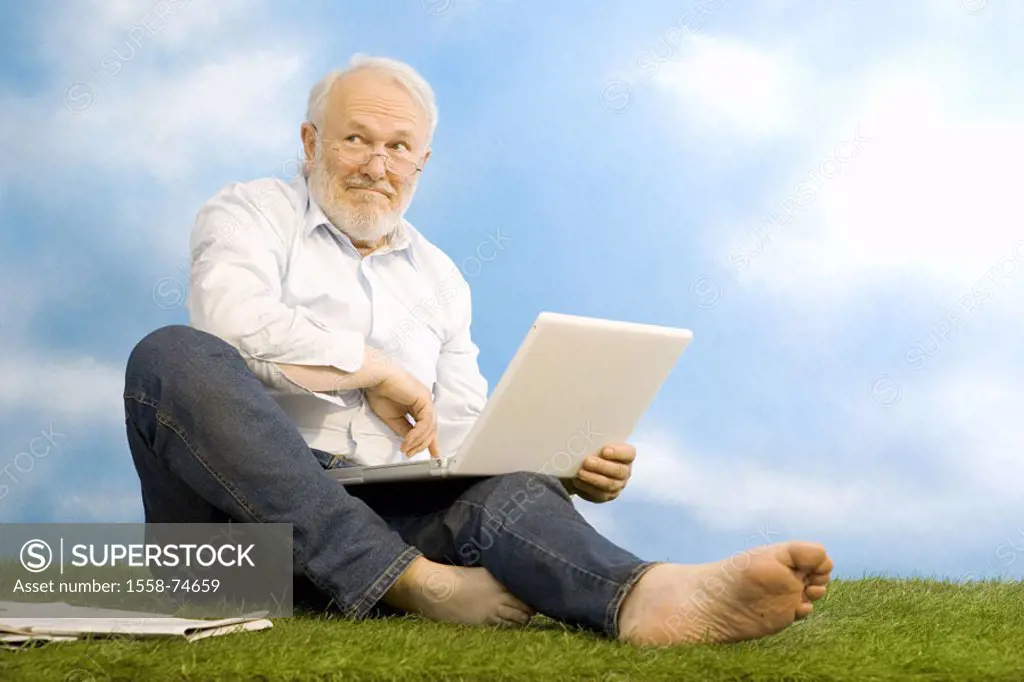 sitting senior, glasses, laptop, meadow,  smiling, gaze on the side, joy  Series, man, 60-70 years, grey-haired, white-haired, beard, jeans, nakedfoot...