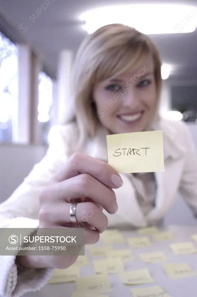 Businesswoman, smiling, note, ´start´,  shows, portrait, fuzziness  Women portrait, blond, self-confidently, note papers, Post-it, communication, hint...