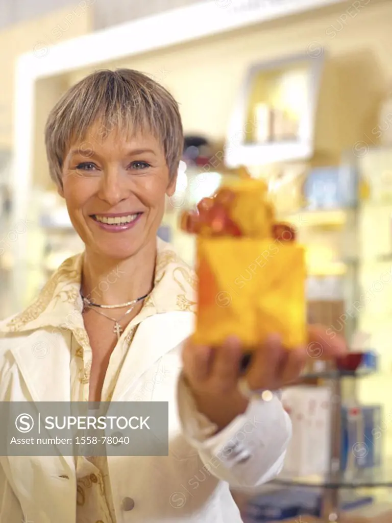 Perfumery, woman, middle age, smiling,  Gift, holding, portrait, fuzziness  Women portrait, well Age, 40-50 years, short-haired, customer, sales assoc...