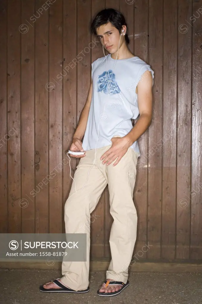 Teenager, MP3-Player, music  hearing, wood wall, stand, nonchalant,  Look camera  Series, boy, youth, teenagers, 14-18 years, MP3, headphone, clothing...