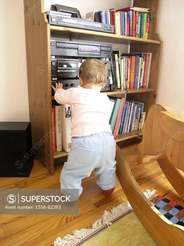 Living rooms, bookshelf, stereo,  Baby, stand, view from behind  Child, girls, toddler, 9 months, development phase, learning process, explores, learn...