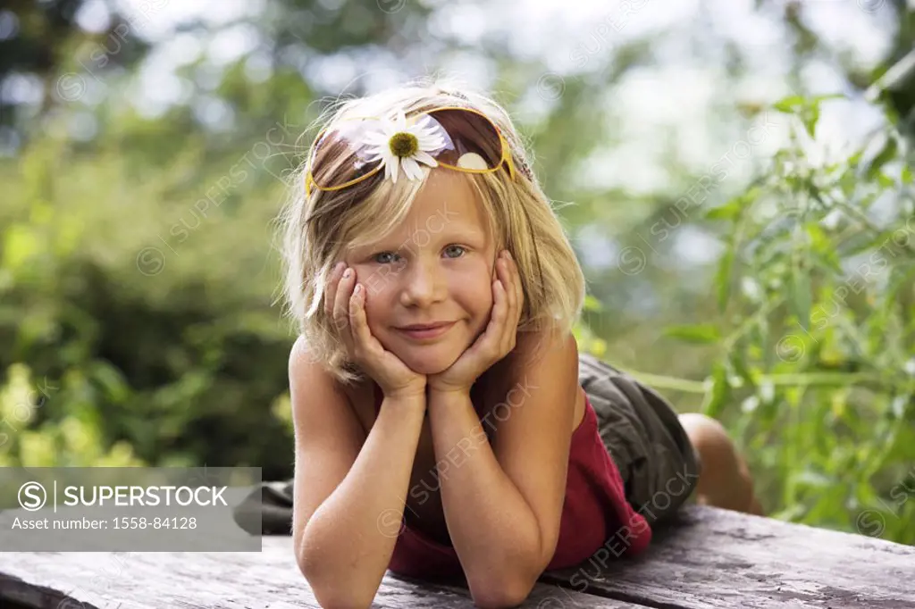 Girls, 6 years, wood table, lie, head  rested, gaze camera   Child, blond, sun glass, glasses, flower, bloom, table, summer, outside, resting, childho...