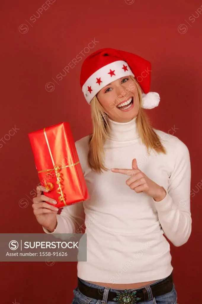 Woman, young, blond, Nikolausmütze,  Christmas gift, holding, laughing,  Half portrait,  Series, ´Christmas woman´, 20-30 years, long-haired, gaze cam...