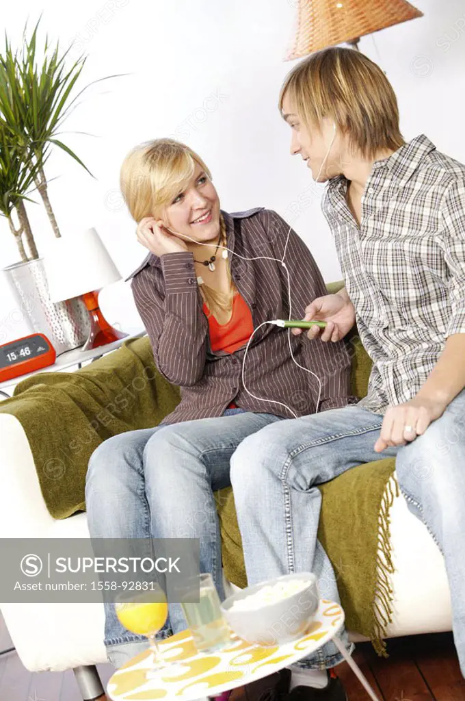 Sofa, teenagers, couple, sitting, MP3-Player,  Headphones, music hearing,   Series, youth, teenagers, teenager couple, 16-18 years, leisure time, Life...