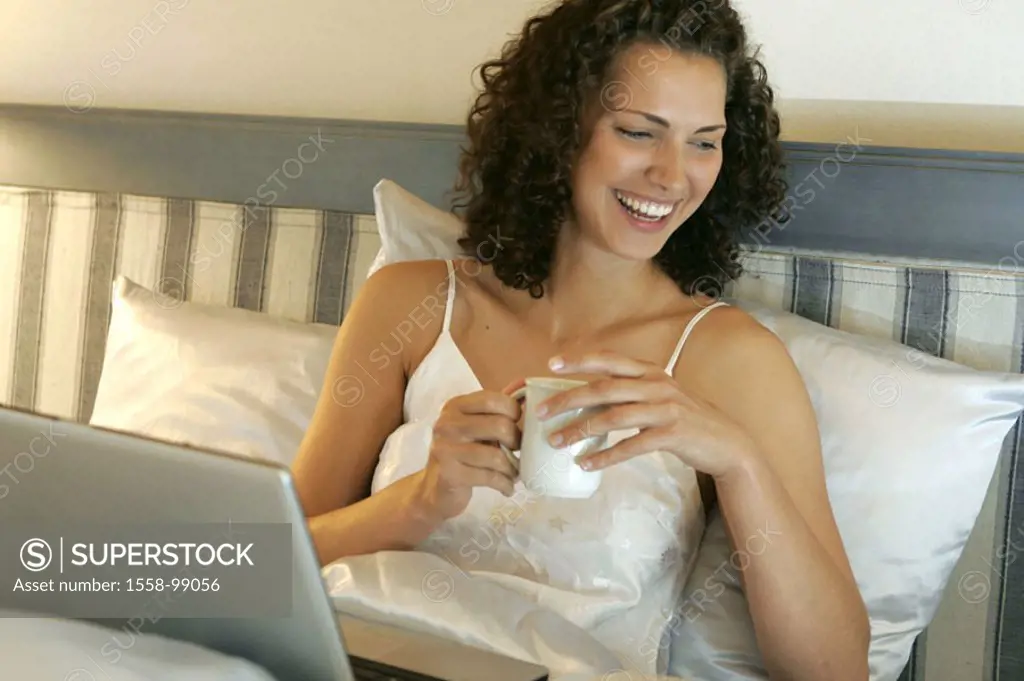Bed, woman, young, smiling, Kaffeetasse,  wegstellen, laptop,   Series, 20-30 years, long-haired, curls, curly, brunette, leisure time, relaxen, mobil...
