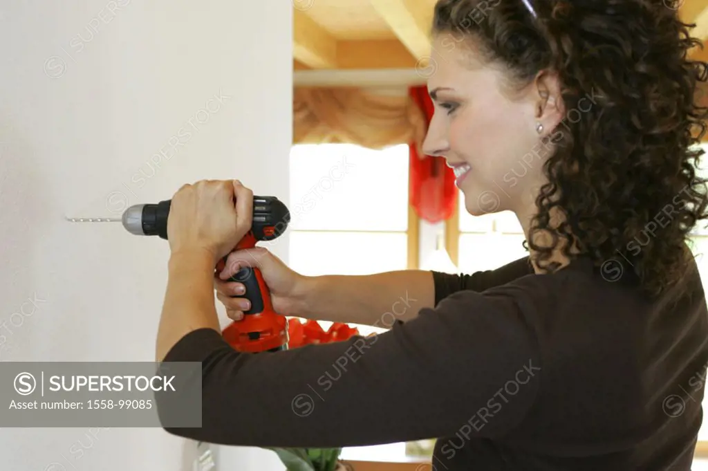 Woman, young, wall, drill, drills,  truncated on the side, half portrait,   Series, 20-30 years, brunette, curls, curly, home works, Do-it-yourself, e...