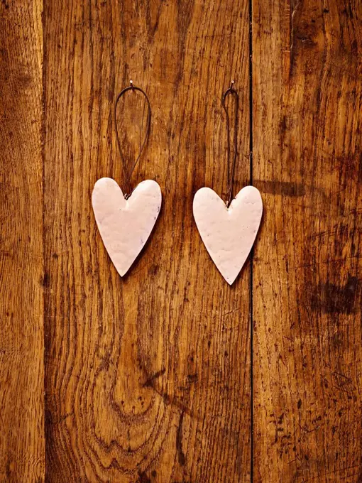 two sheet metal hearts on a brown table