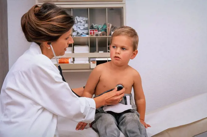 Doctor examines small boy in practice close the stethoscope