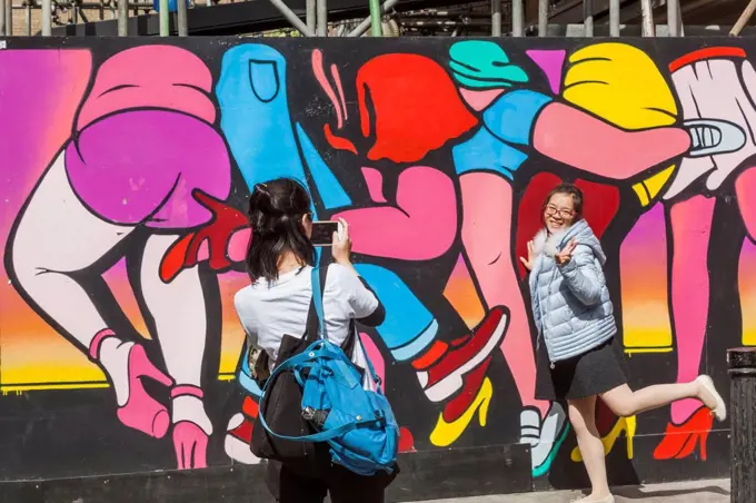 England, London, Shoreditch, Spitalfields Market, Asian Tourists Posing with Wall Art