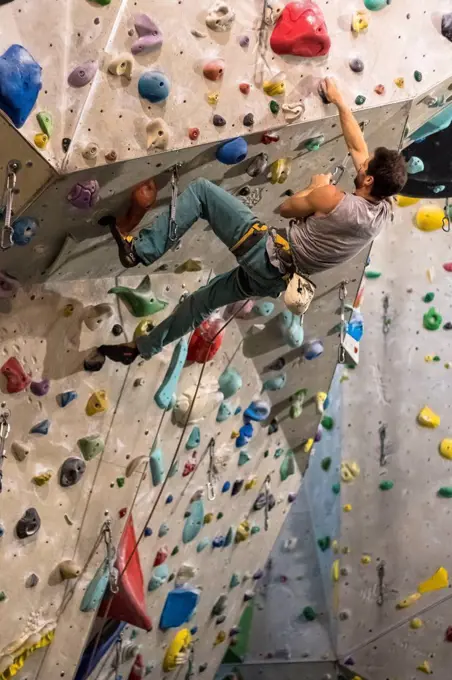 Germany, Baden-Württemberg, Stuttgart, climbing gym, female climber in an overhang on the climbing wall