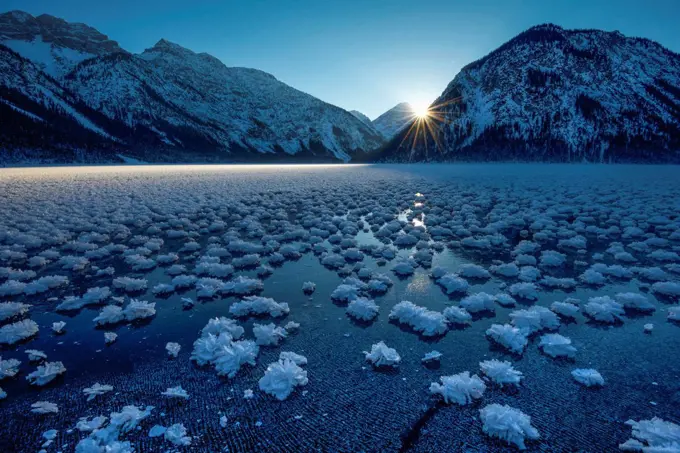 frost flowers on the frozen Plansee in Austria, last rays of sunshine in the afternoon