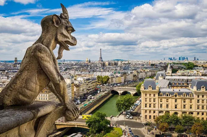 Gargoyle on Notre Dame with skyline of Paris and Eiffel tower, France
