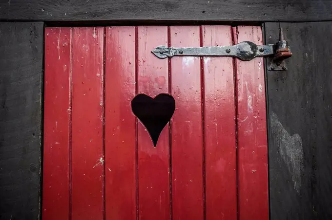 Detail of a red toilet door with heart