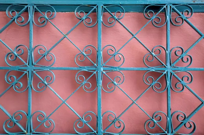 stylized iron grid in front of pink background in Greece
