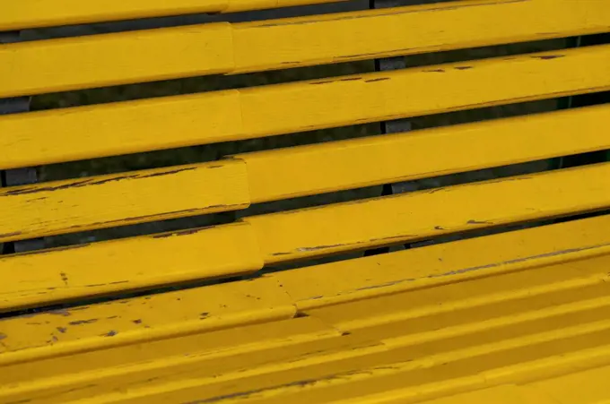 Partial view of yellow wooden bench, Vienna, Austria