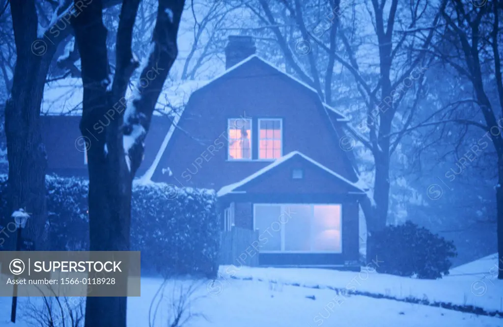 Woman in window at dusk in snowstorm. Winchester. USA