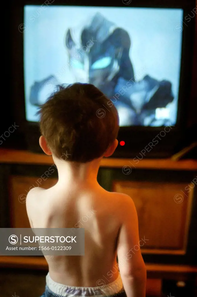 Two-year old boy standing in front of television watching children´s show