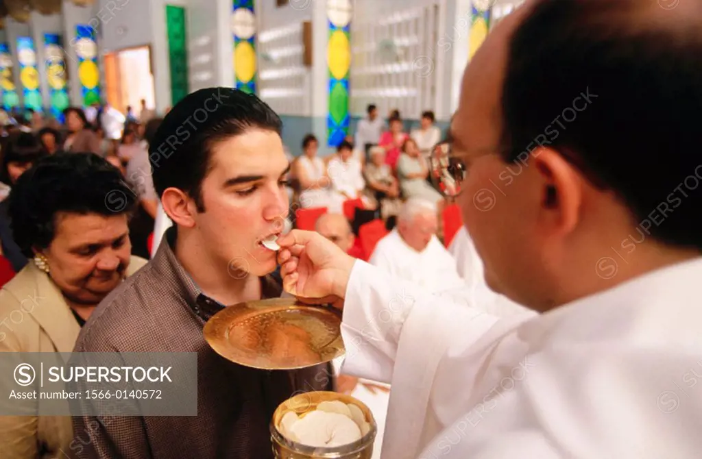 Priest giving the Communion during mass