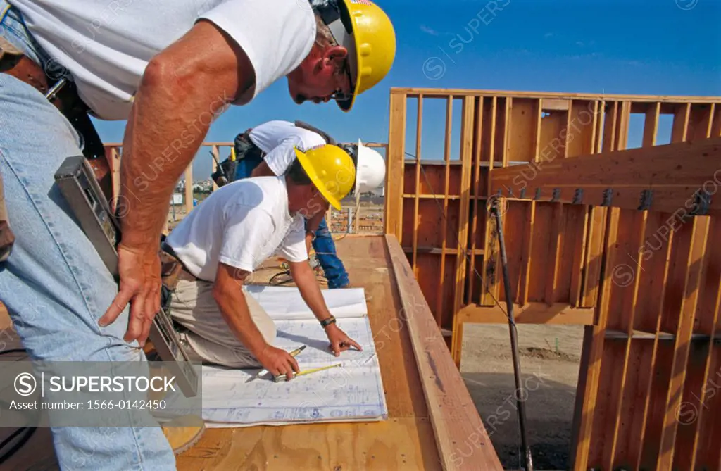 Construction foreman giving instructions to carpenters on jobsite for school construction, Antelope California USA