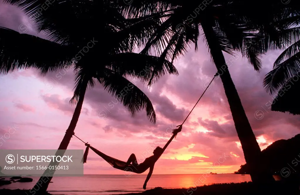 Sunset in hammock on tropical island beach