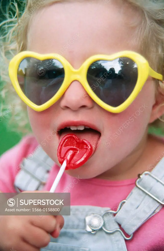 Little girl licking her lollipop