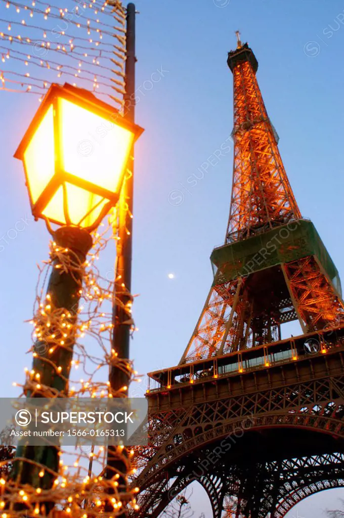 Eiffel Tower and lightpost wrapped in Christmas lights. Paris. France