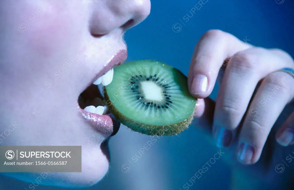 womans mouth eating kiwi fruit