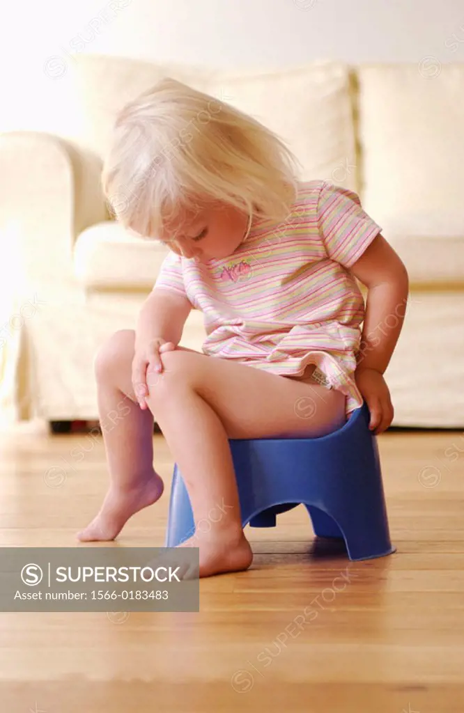 Toddler girl using potty