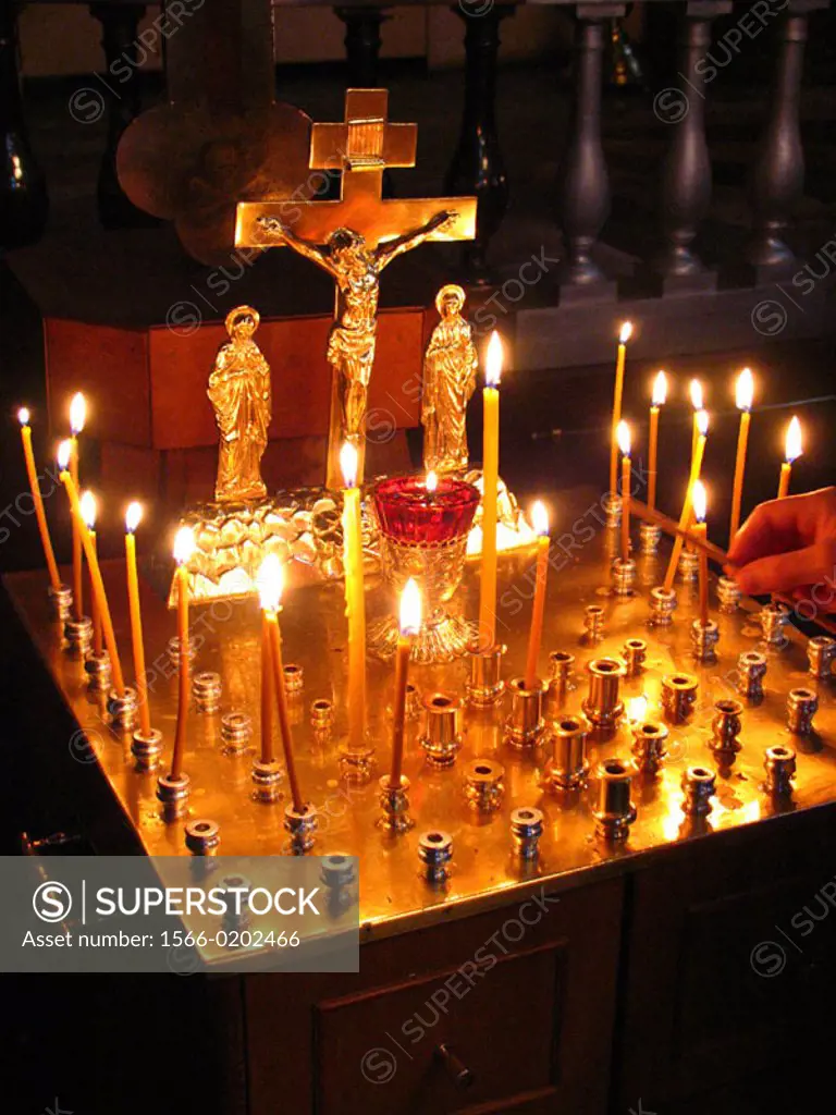 Candles lit Orthodox cross in Church of the Bleeding Savior, Russian revival style architecture. St. Petersburg. Russia