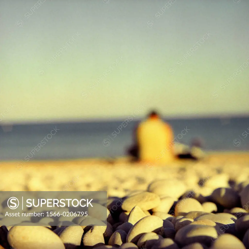Adult and pebbles in Albir beach, Alfaz del Pi, Alicante province, Spain