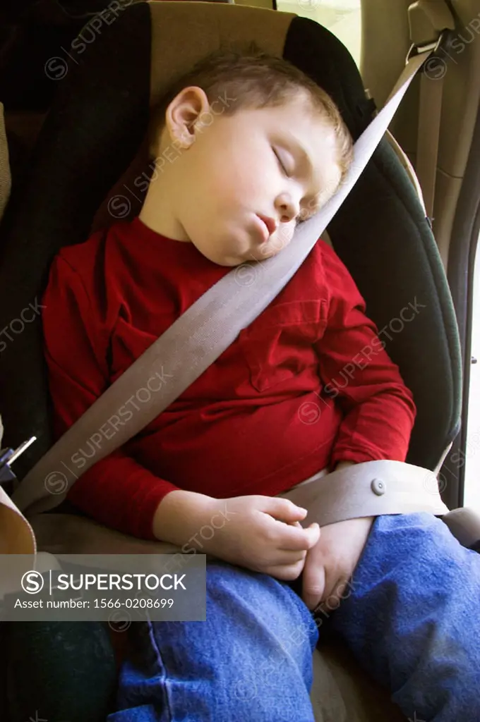 boy sleeping in car seat