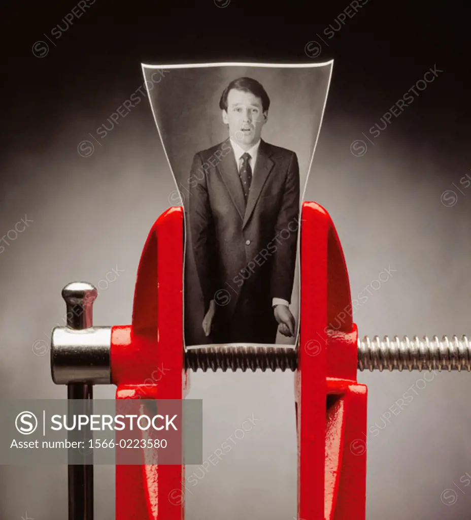 B/W photo of business man; photo in red vise as though the man were being squeezed. Man looks distressed.