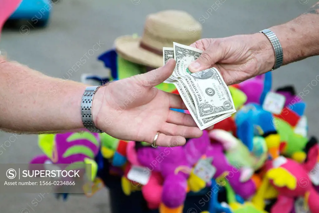 Cash money changing hands between a buyer and seller